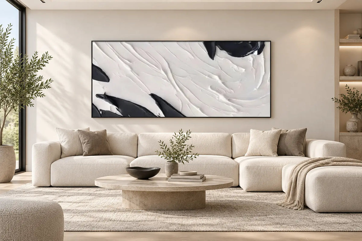 Oversized black and white textured wall art displayed above a cream sofa